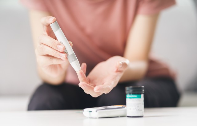 Woman using lancet on finger for checking blood sugar level. Credit: Istock.com/Suriyawut Suriya